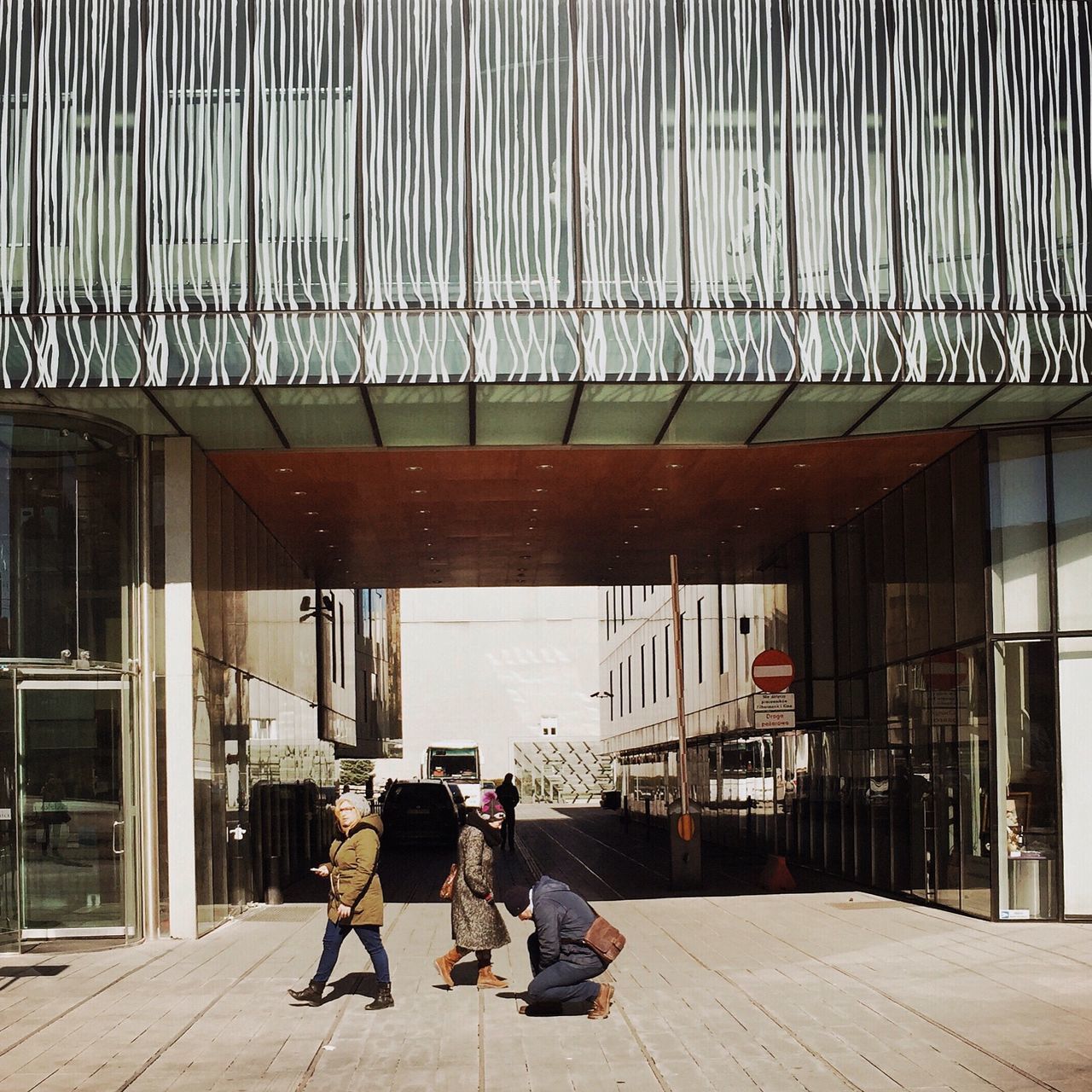 architecture, built structure, men, lifestyles, building exterior, person, leisure activity, full length, walking, city, chair, rear view, city life, sitting, casual clothing, day, sunlight, medium group of people