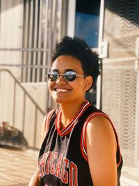 Portrait of young woman wearing sunglasses standing in city