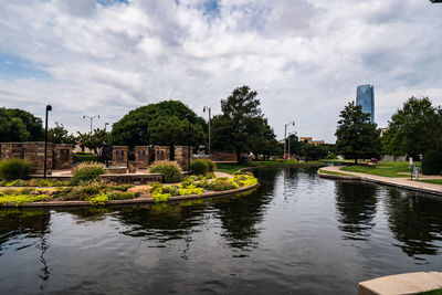 Scenic view of lake by buildings against sky