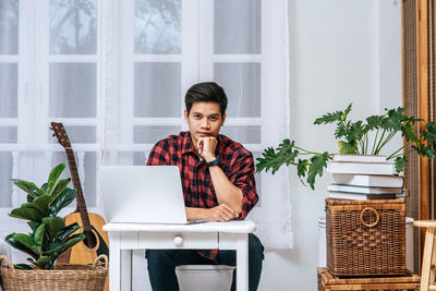 Young man using mobile phone at home