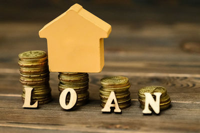 Close-up of coins with model home and loan text on table