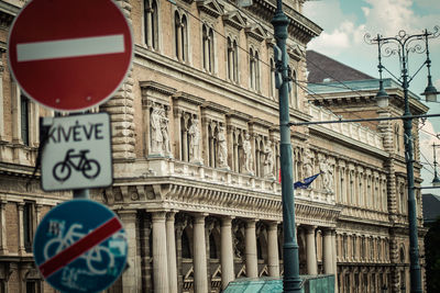 Low angle view of road sign by building