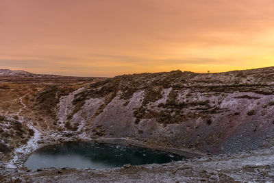 Scenic view of waterfall against sky during sunset