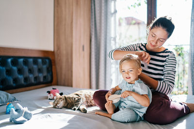 Portrait of siblings sitting on sofa at home