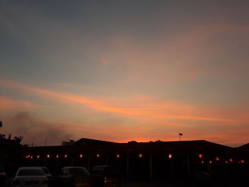 Silhouette cars on city against sky during sunset