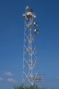 Low angle view of communications tower against blue sky