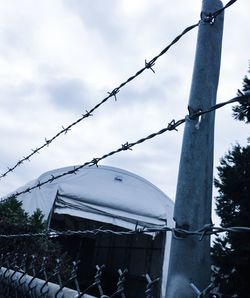 Low angle view of fence against sky