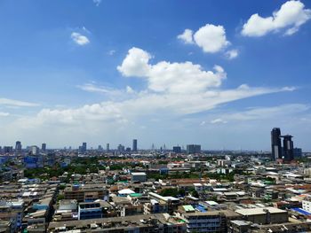 Aerial view of buildings in city against sky