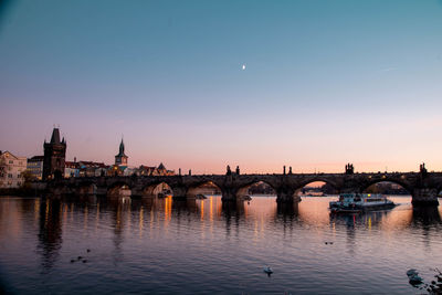 View of bridge over river at sunset