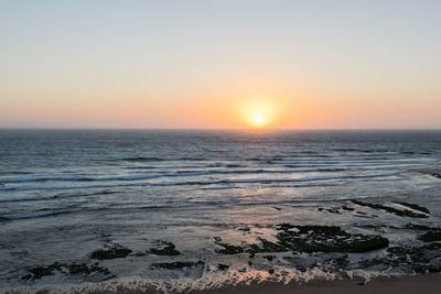 Scenic view of sea against clear sky during sunset