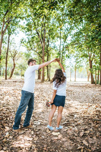 Happy couple dancing in forest during autumn