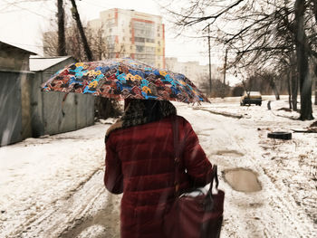 Rear view of woman standing in snow