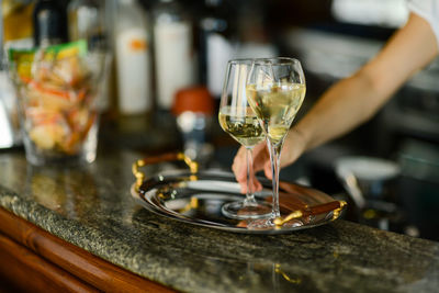 Hands of young adult caucasian female barista preparing white wine