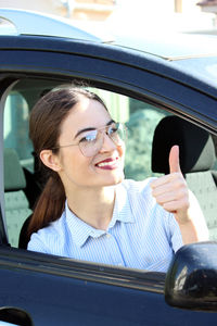 Portrait of a smiling young woman in car