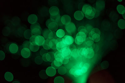 Defocused image of illuminated red light against black background