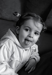 Close-up portrait of cute baby girl on bed at home