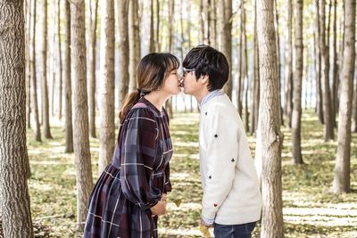 Young couple kissing in forest