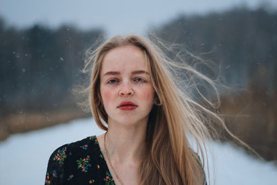 Portrait of young woman standing against sky at night