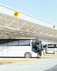 Bus parked by metal structure in city