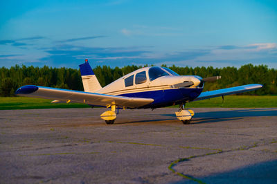 Airplane on airport runway against sky