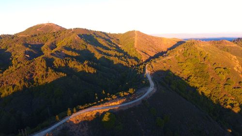 Scenic view of road by mountains against sky