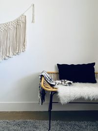 Macrame and sofa against white wall
