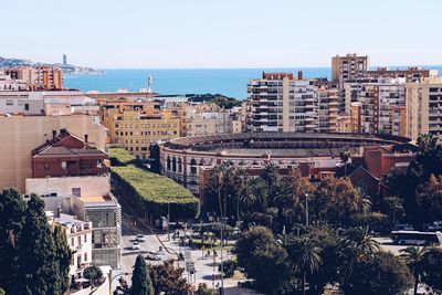 High angle view of buildings by sea against clear sky