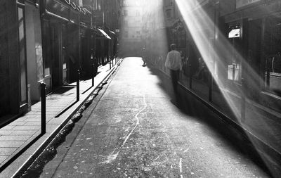 Rear view of man walking on street in city