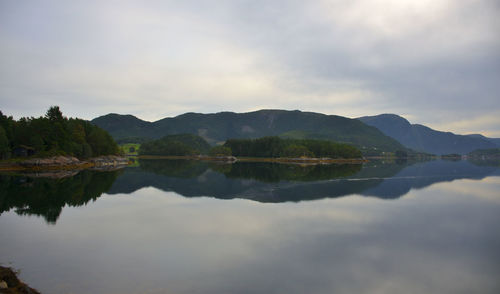 Scenic view of lake by mountains against sky