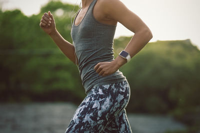 Midsection of woman running at park