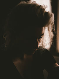 Close-up portrait of a young woman looking at home