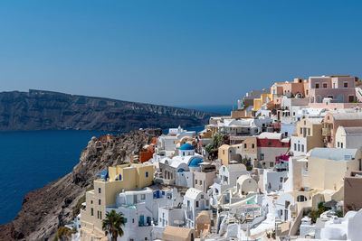 High angle view of townscape by sea against clear sky