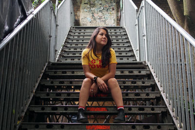 Portrait of young woman sitting on staircase