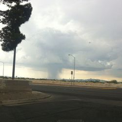 Empty road against cloudy sky