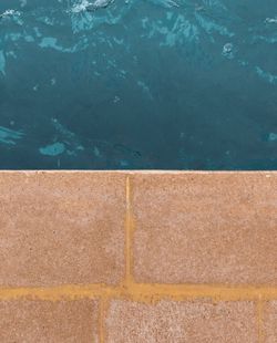 High angle view of yellow wall by swimming pool