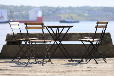 Empty chairs and table on beach