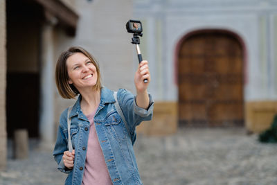 Full length of woman holding smiling while standing in city