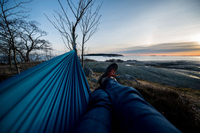 Low section of man relaxing on hammock