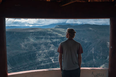 Rear view of man looking at mountains from observation point