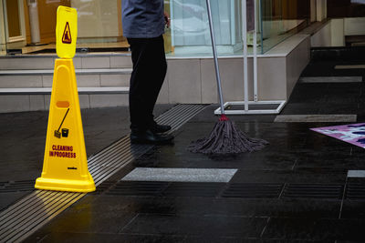 Low section of man with text on tiled floor