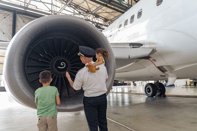 Rear view of man with airplane on airport