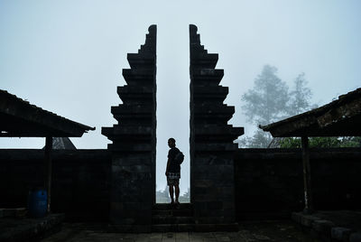 Man standing amidst wall against sky