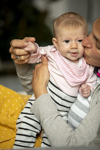 Midsection of mother kissing while holding baby girl