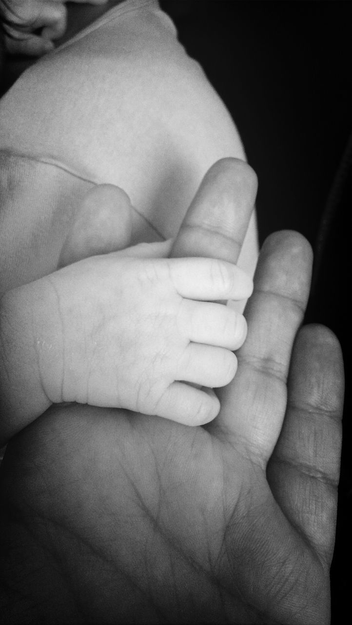 person, part of, human finger, close-up, indoors, cropped, holding, lifestyles, love, black background, bonding, togetherness, baby, leisure activity, studio shot