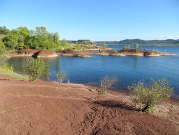 Scenic view of lake against clear blue sky