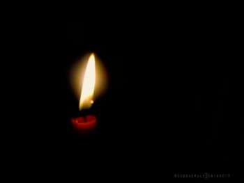 Close-up of lit candle in dark room