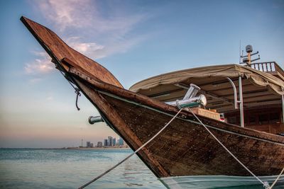 Old boat moored on sea against sky