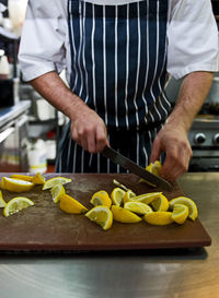 Chef chopping fresh lemon at restaurant in the uk
