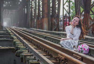 Portrait of smiling woman on railroad tracks