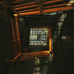 Directly below view of metallic spiral staircase against skylight in building